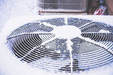 air conditioning unit covered in fresh snow